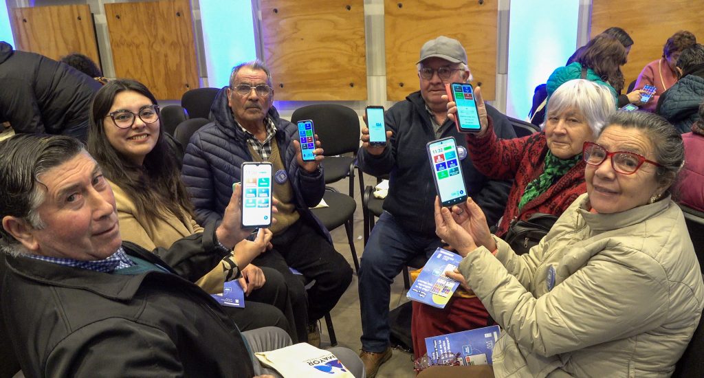 Grupo de vecinos mayores de Ñuble muestran App Mayor en sus teléfonos.