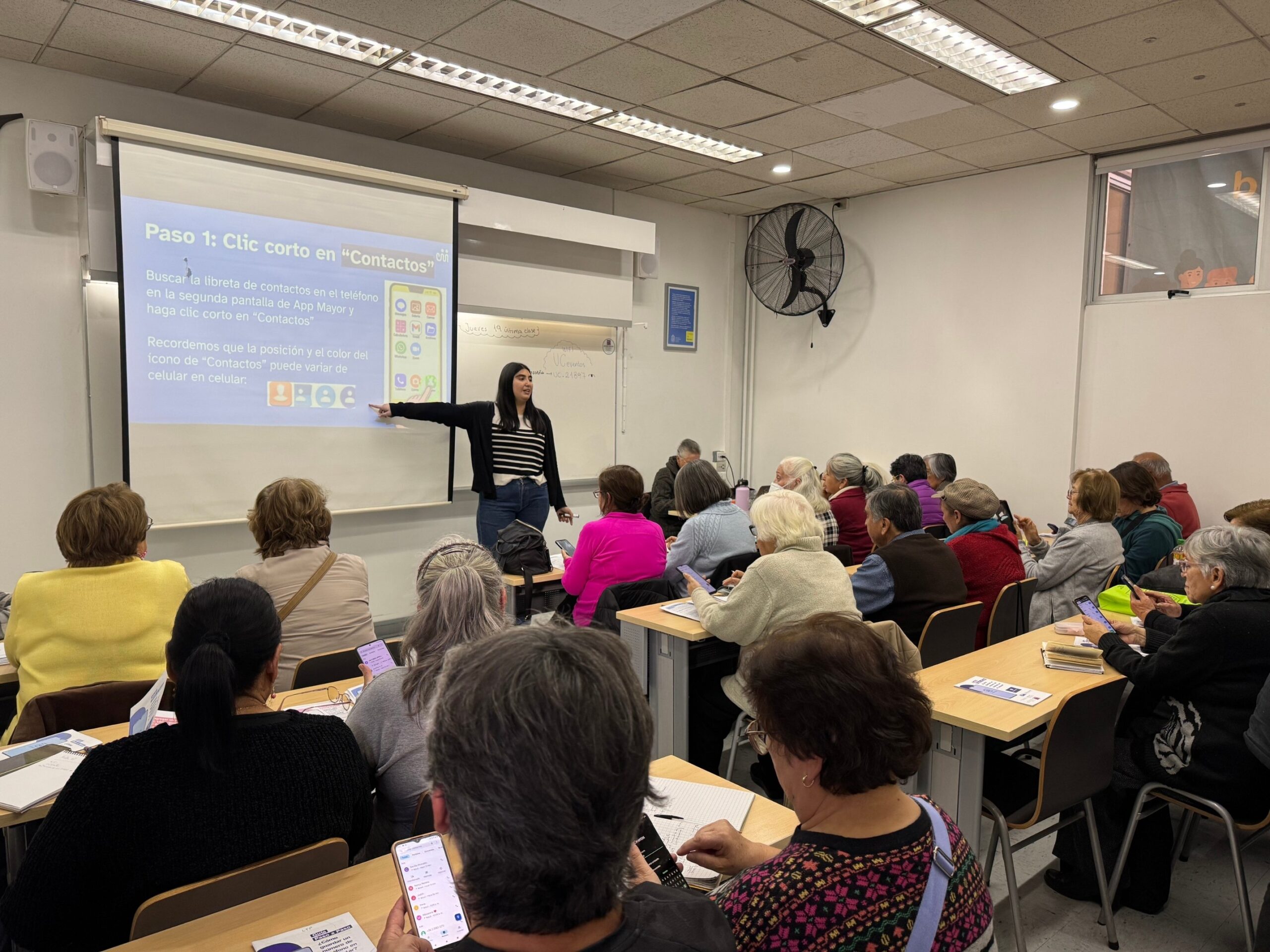 Voluntaria UC haciendo clases a personas mayores